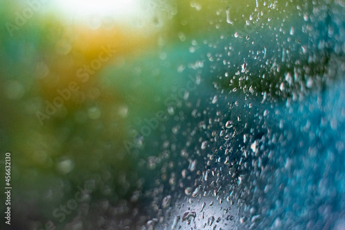 Raindrops on the window. Colored background with wet glass. Misted glass.