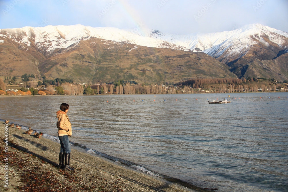 A woman standing at the edge of lake Wanaka in New Zealand.