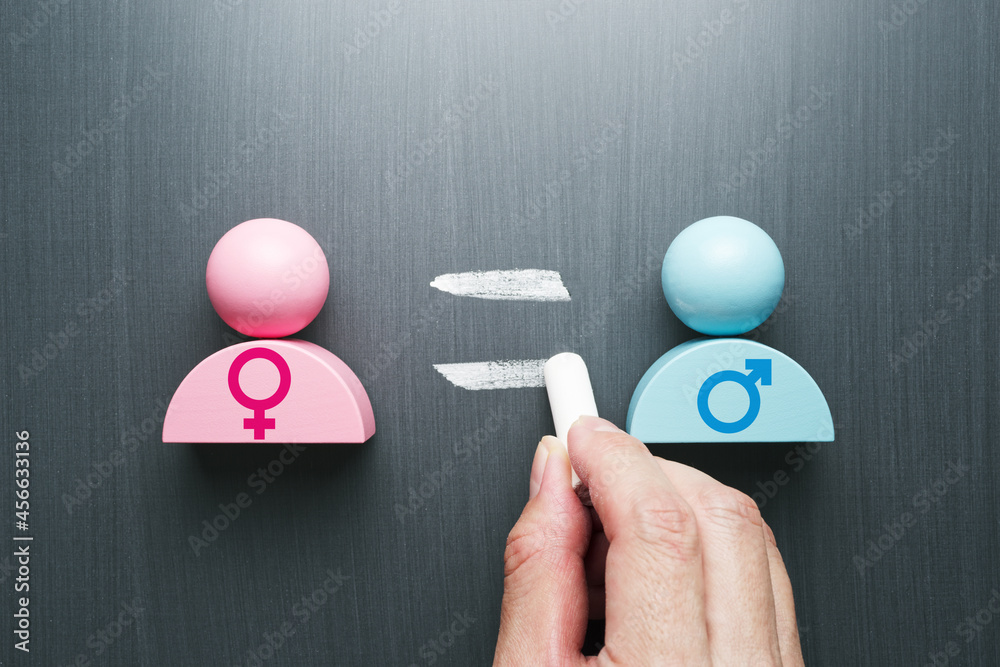 Concept image of gender equality. Female and male symbols. Hand writing equal sign on blackboard. - obrazy, fototapety, plakaty 