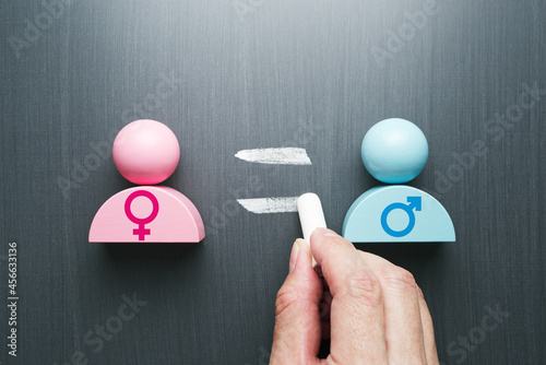 Concept image of gender equality. Female and male symbols. Hand writing equal sign on blackboard. photo