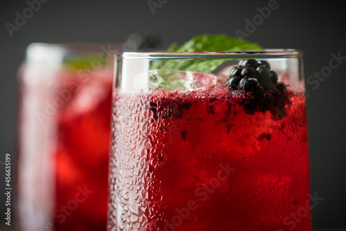 Blackberry cocktail with crushed ice on the rustic wooden background. Selective focus. Shallow depth of field.
