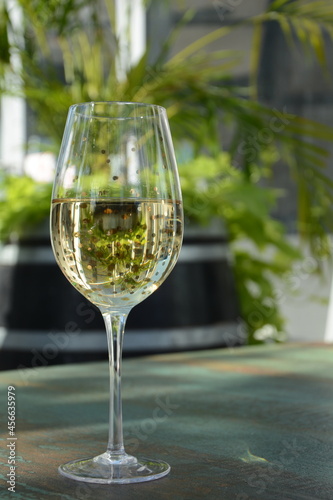 A glass of white wine with grapes on wooden table. White wine Riesling, from white grapes