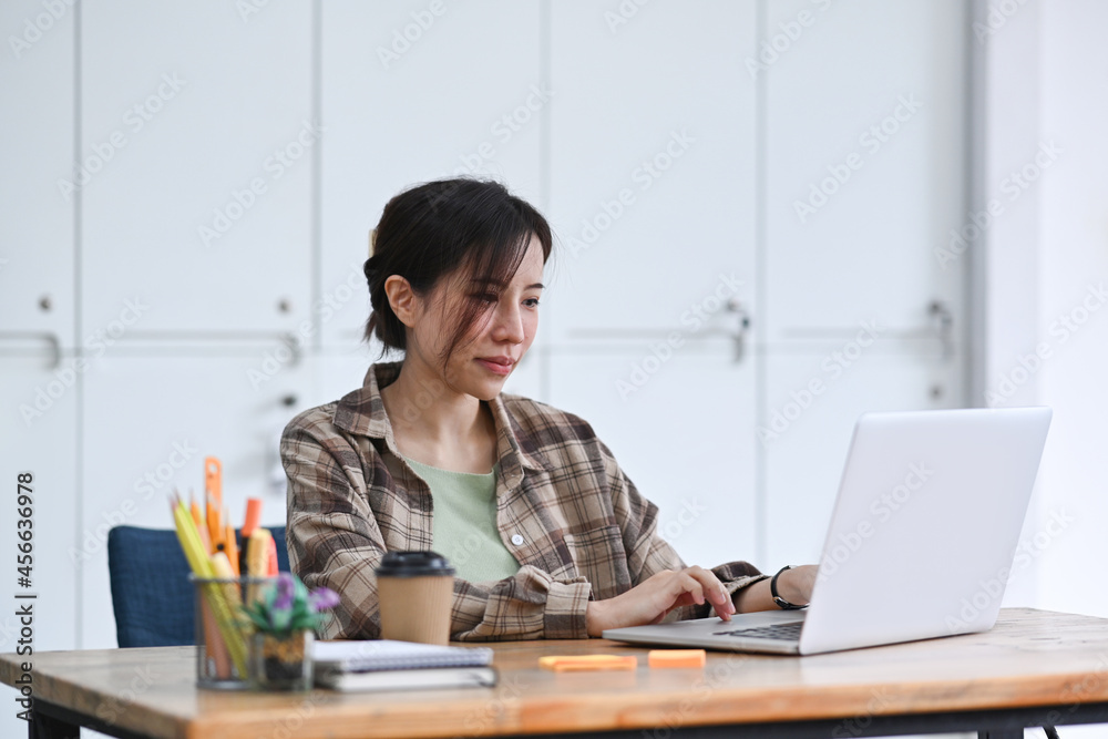 Female designer working with computer laptop in creative workplace. Female designer working with computer laptop in creative workplace.