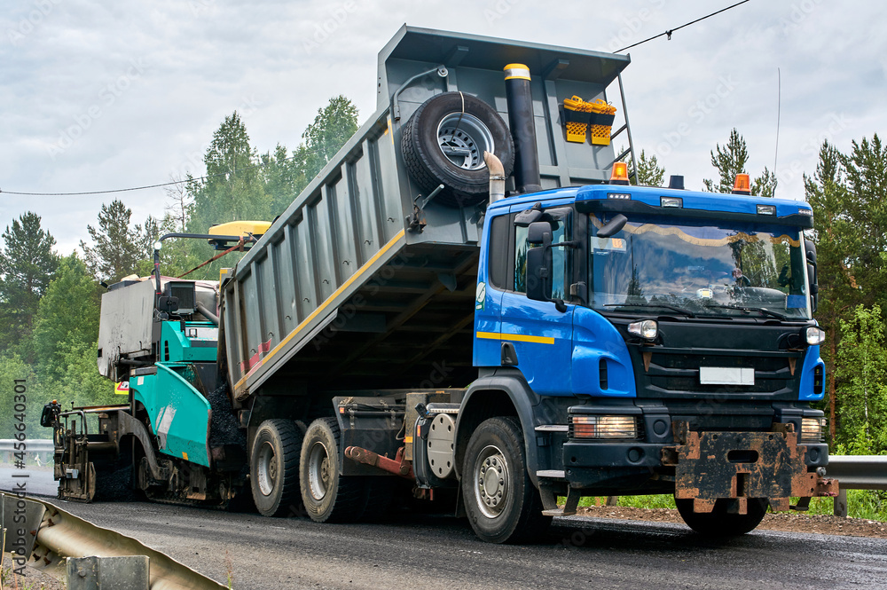 unloading of asphalt into an asphalt paver and laying of asphalt with the help of an asphalt paver unloading of asphalt into an asphalt paver and laying of asphalt with the help of an asphalt paver