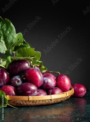 Purple plums with leaves.