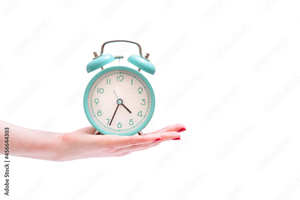 photo of female hands holding alarm clock on isolated white background photo of female hands holding alarm clock on isolated white background