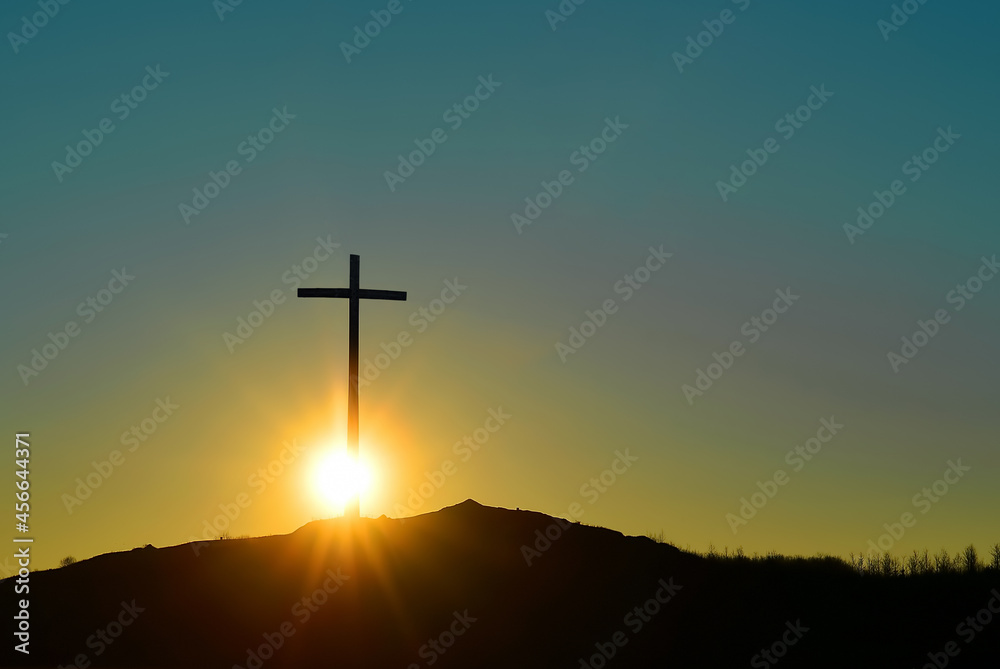 Christian cross over beautiful sunset background, concept of spirituality