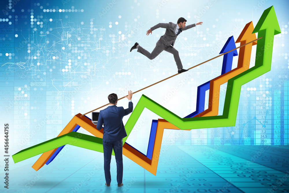 Businessman balancing on tightrope on line chart Businessman balancing on tightrope on line chart