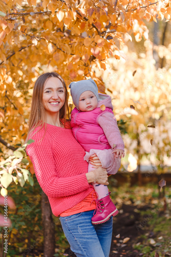 young beautiful mother keeps a one-year-old girl on an autumn natural background young beautiful mother keeps a one-year-old girl on an autumn natural background