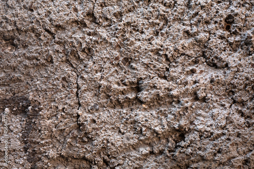 Grey concrete surface. exterior cement wall with small stones. Background, Wallpaper textured picture. top view. Nobody. Copy and test space. Aged wall pattern. Construction work