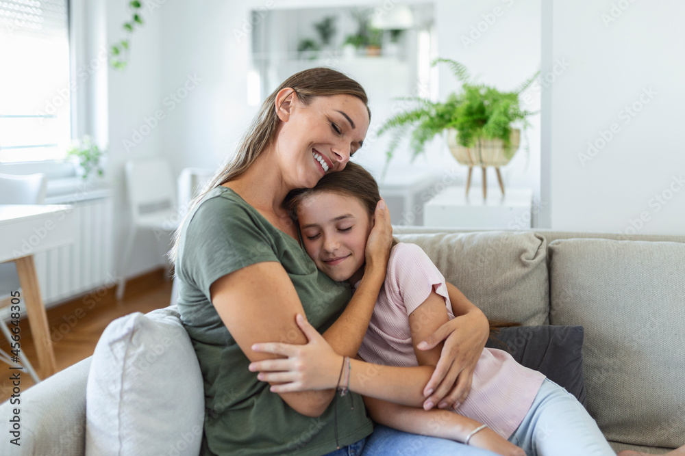 I love you so much. Portrait of happy young mother piggybacking cute smiling little daughter in living room, affectionate school age girl embracing beloved millennial female nanny or foster mom