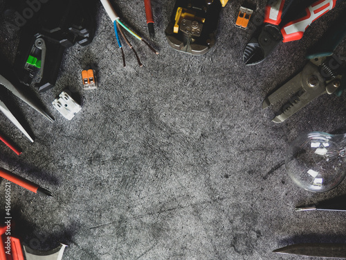 Flat lay composition with electrician's tools and space for text on gray concrete background