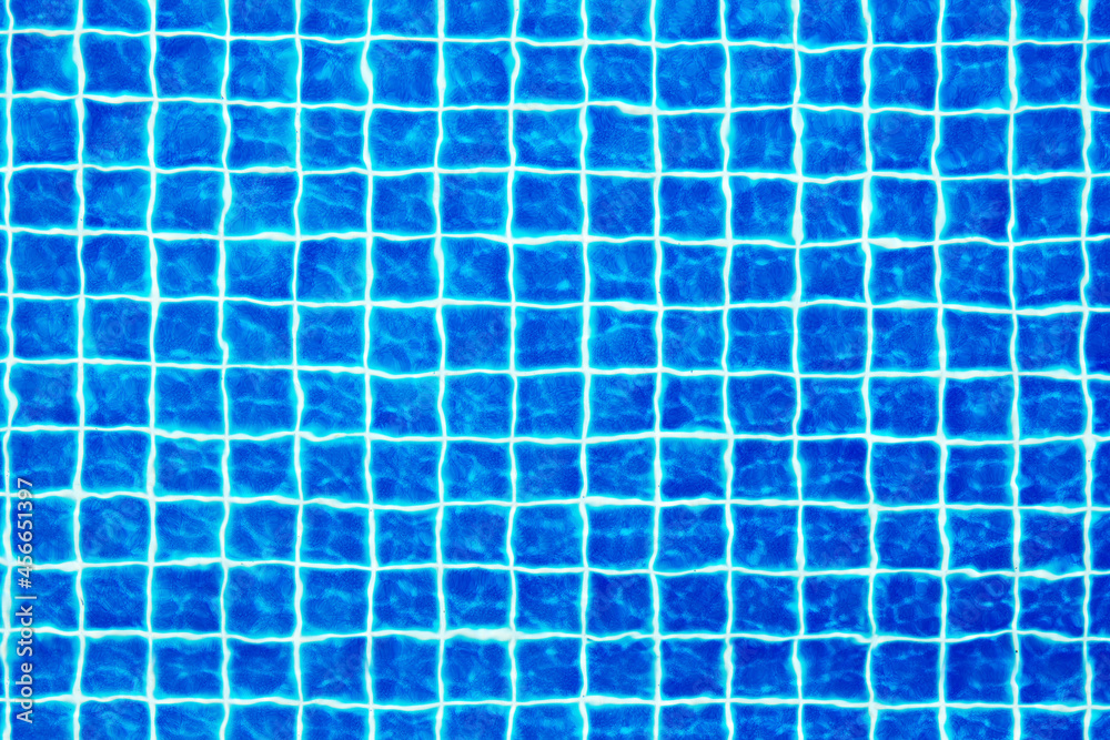 Swimming pool surface texture close up top view, blue water background, caustics ripple, swimming pool tiled bottom backdrop, sea beach summer holidays, vacation concept, wallpaper, empty copy space