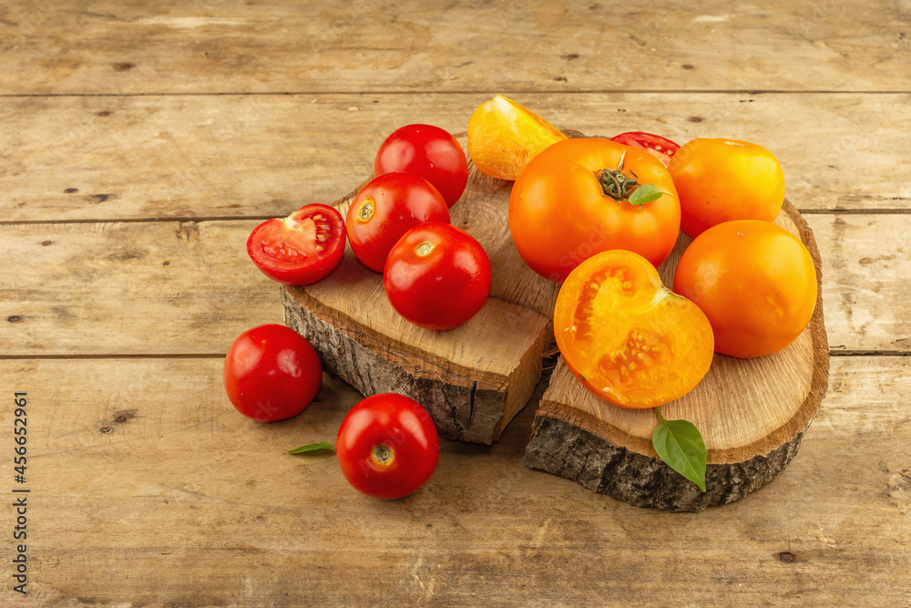 Assorted ripe tomatoes on a wooden stand. Fresh red and orange organic vegetables Assorted ripe tomatoes on a wooden stand. Fresh red and orange organic vegetables
