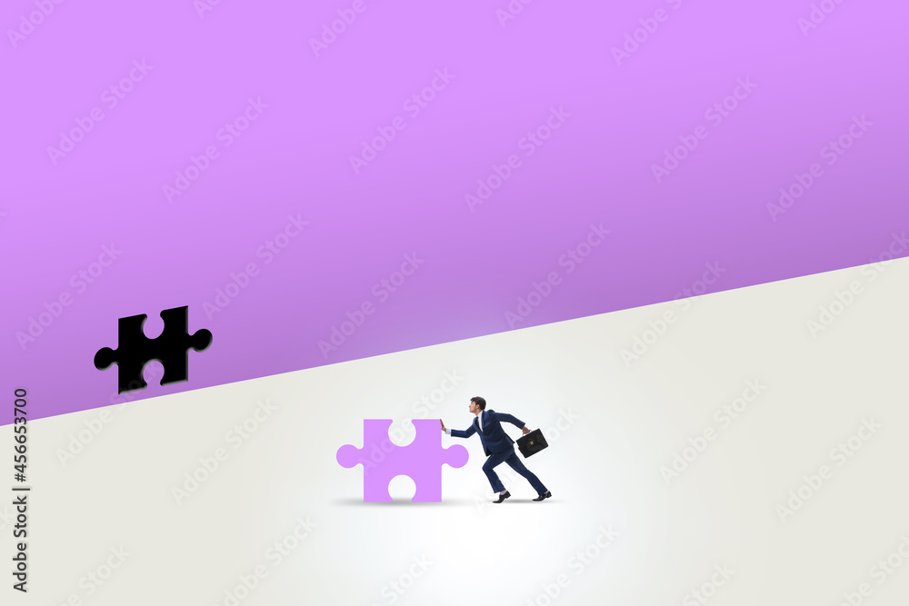 Businessman putting missing jigsaw puzzle piece