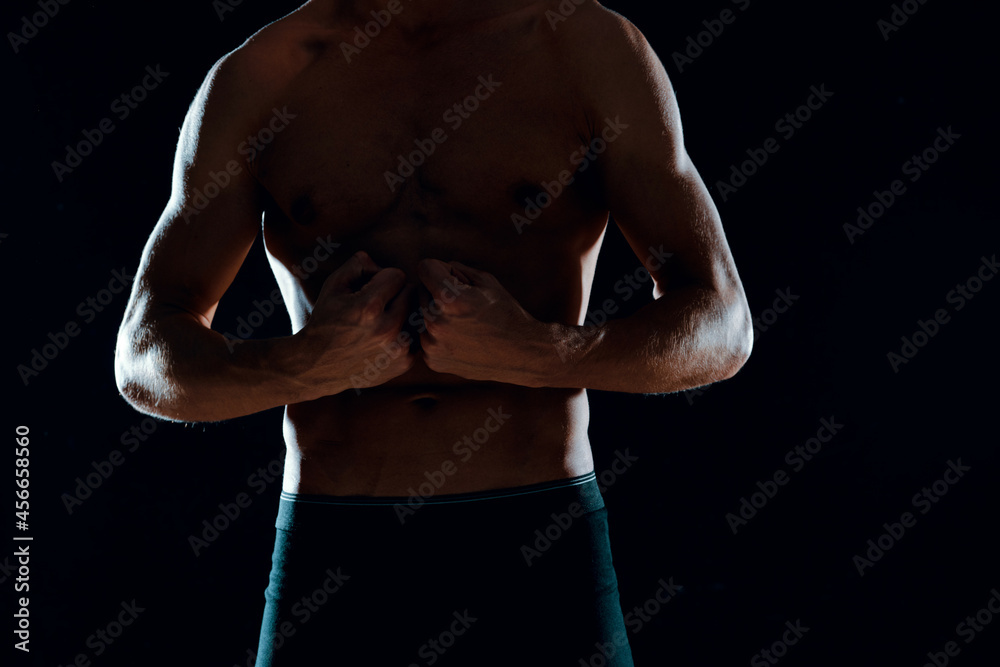 Fototapeta premium man with muscular abs cropped view of gym dark background