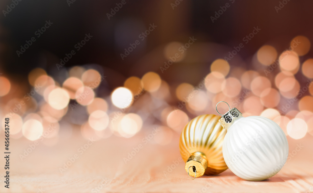 two christmas ornaments on a background of defocus lights two christmas ornaments on a background of defocus lights