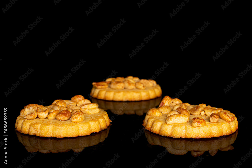 Group of three whole delicious cookie with peanuts on black glass