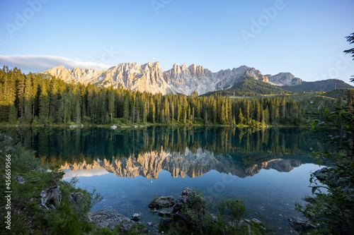 Splendid view of Lake Carezza in South Tyrol. The mountains and the forest are perfectly reflected on the lake, a suggestive image. A dream place for a relaxing holiday in nature.