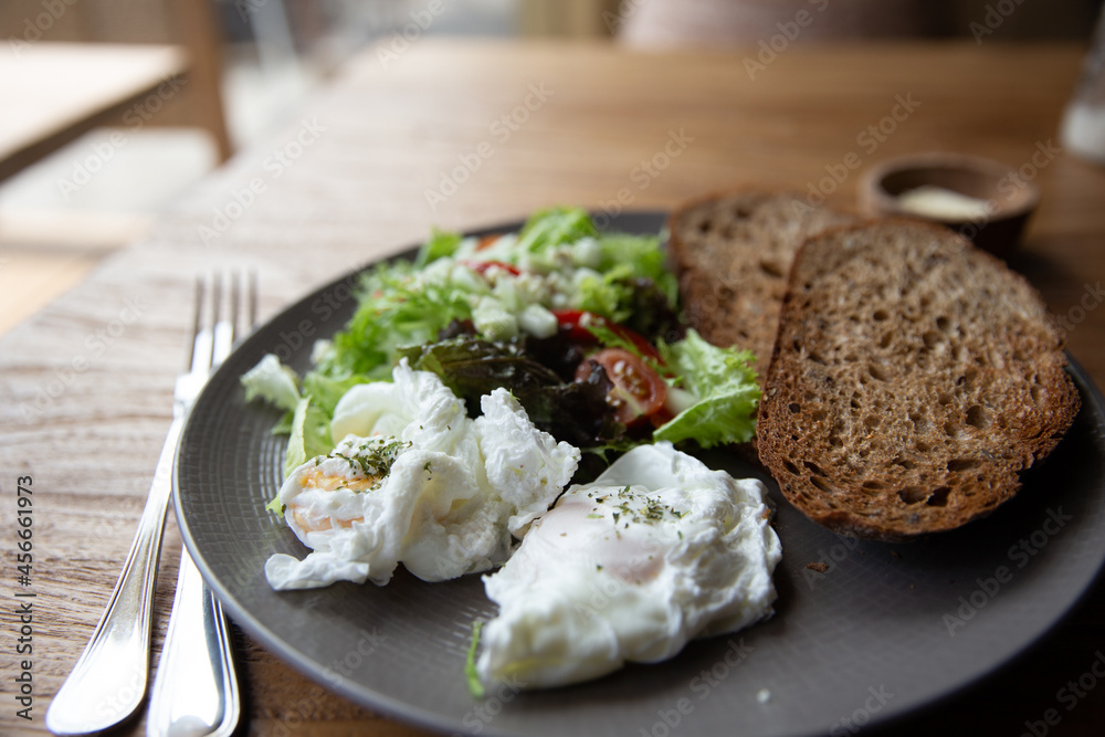 Fried Eggs on Wholegrain Toast and green salad for Breakfast. on wooden table Fried Eggs on Wholegrain Toast and green salad for Breakfast. on wooden table