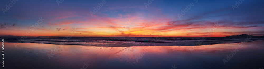 Panorama sunset ocean beach of Spain city Tarifa Andalusia. Atlantic Ocean waves background bright magic sunset sky