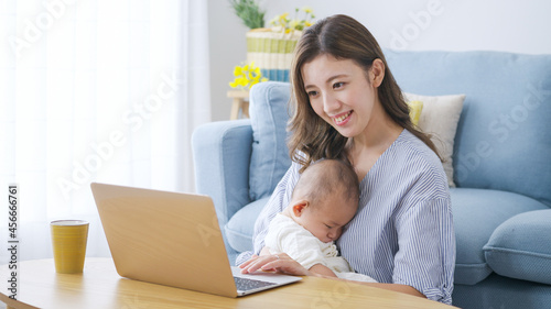 パソコンで仕事をするママと赤ちゃん（家族・ファミリー・育児・子育て・ビジネス）
