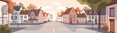 City street at sunset in summer. Town panorama with road, sidewalk, houses in urban residential district. Empty cityscape background with buildings, trees and skyline. Colored flat vector illustration