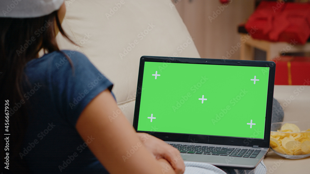 Naklejka premium Close up of person watching horizontal green screen on laptop. Woman looking at chroma key on modern device with isolated background and mockup template. Adult with gadget screen