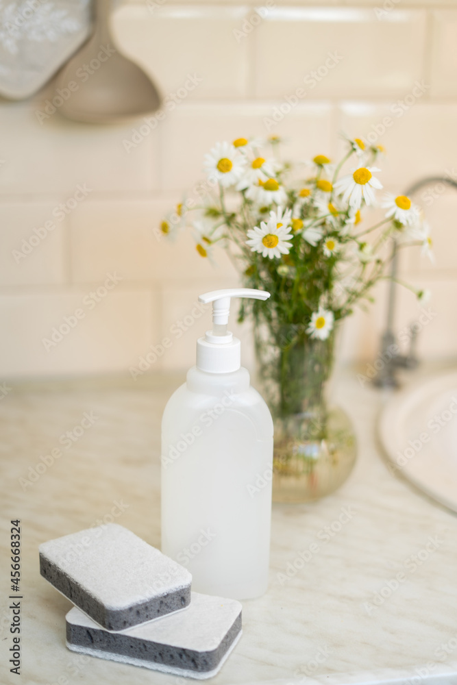 Eco friendly non-toxic cleaning dish soap with chamomile flowers, clean white plates