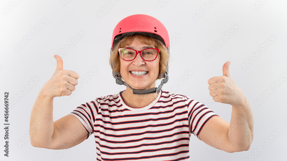Elderly woman in ski helmet showing thumb up on white background. Elderly woman in ski helmet showing thumb up on white background.