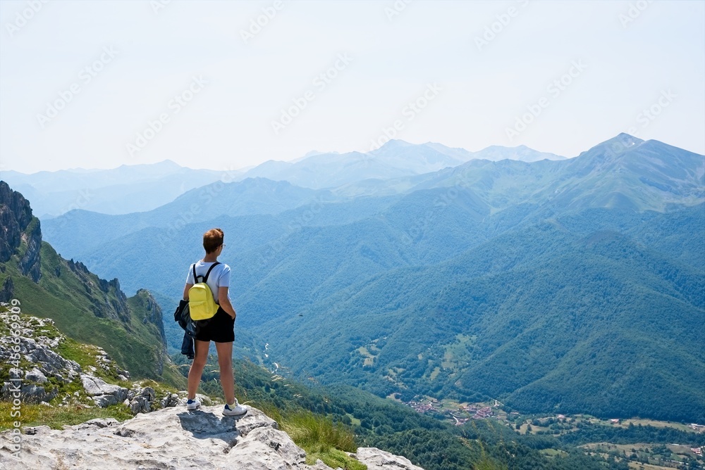 Lonely traveler woman looking at the mountains in Fuente De, Spain