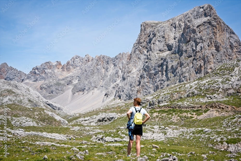 A woman looks at the rocky mountainous landscape 