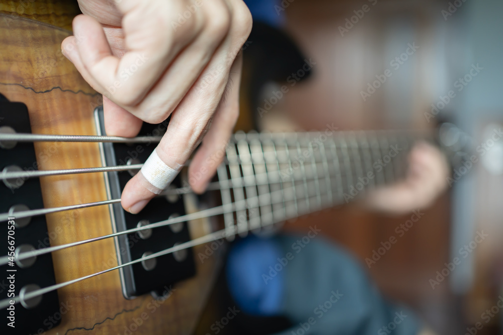 Fototapeta premium Musician playing electric bass with injured finger