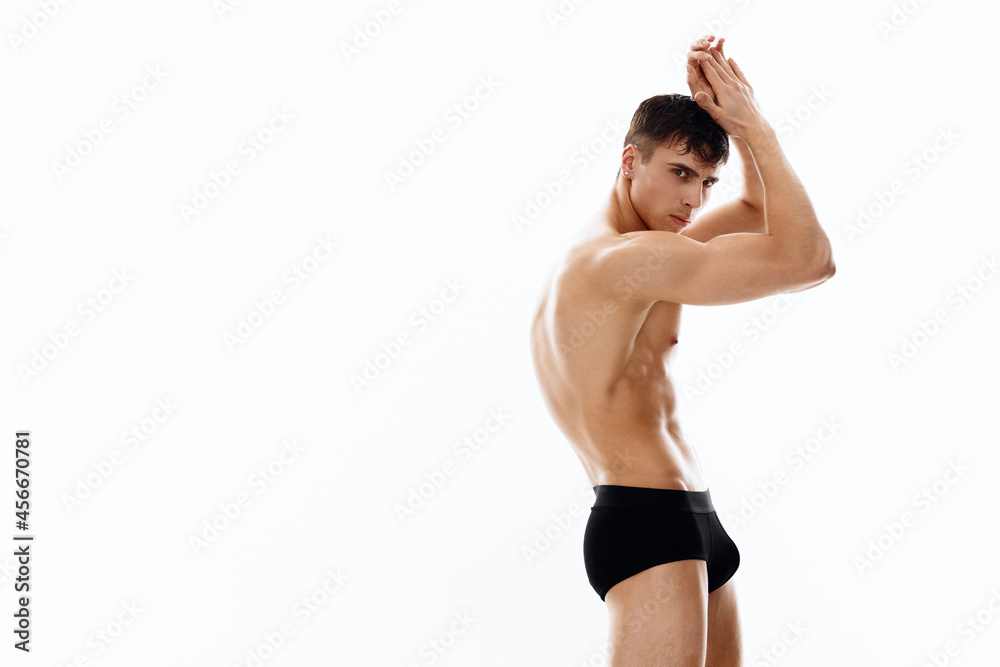 guy on a light background with arms raised up naked torso bodybuilder