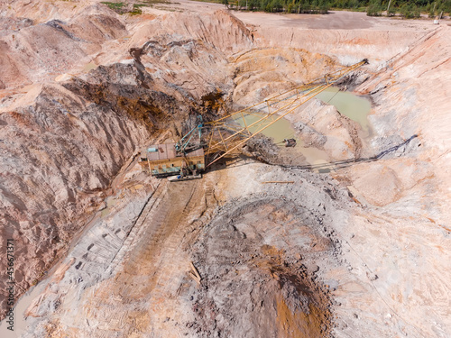 Boom walking excavator digs ilmenite ore in quarry, aerial view photo