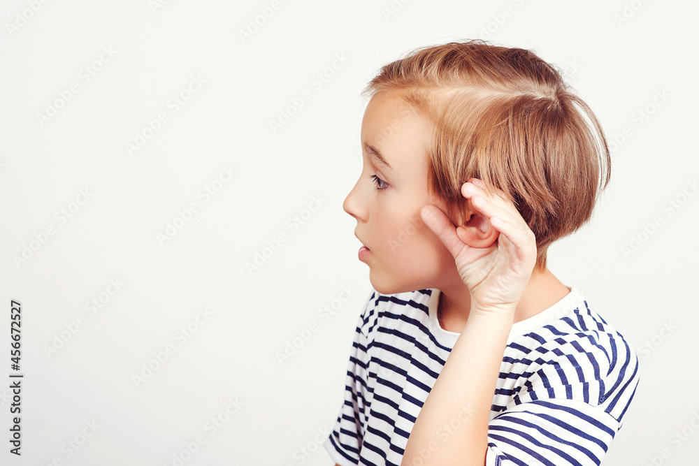 Child hearing gossip, over white background. School boy hearing something, hand to ear gesture. Child hearing gossip, over white background. School boy hearing something, hand to ear gesture.