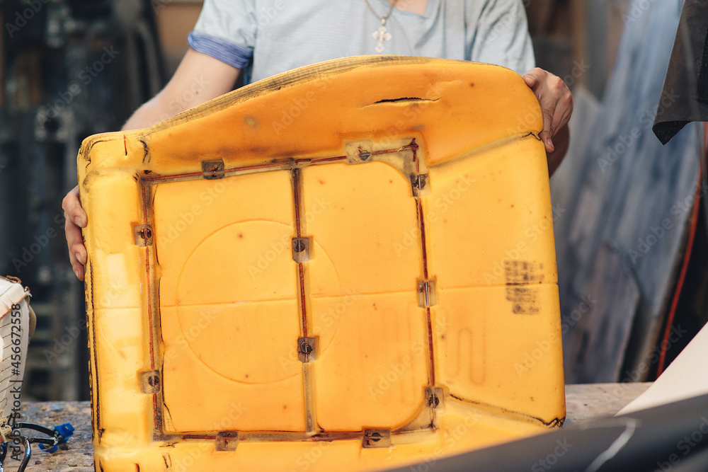 Repair of the old car seat. Car mechanic's hands is using tools. Stock Photo Adobe Stock