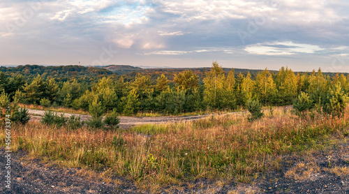 view from the mining heap on forests and other heaps and mining infrastructure. panorama of the autumn forest seen from the mining heap
