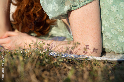 European young girl hands closeup on green grass
