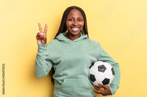 smiling and looking friendly, showing number two or second with hand forward, counting down. soccer concept photo