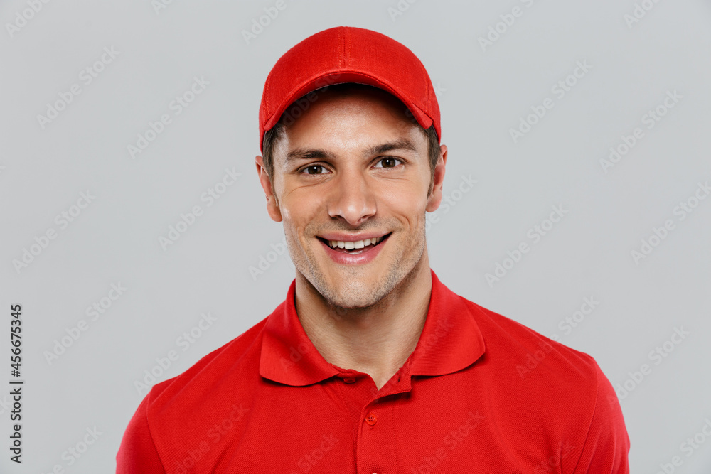 Young delivery man wearing uniform smiling and looking at camera Young delivery man wearing uniform smiling and looking at camera