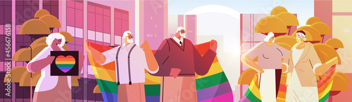 mix race senior people holding lgbt rainbow flags gay lesbian love parade pride festival transgender love concept