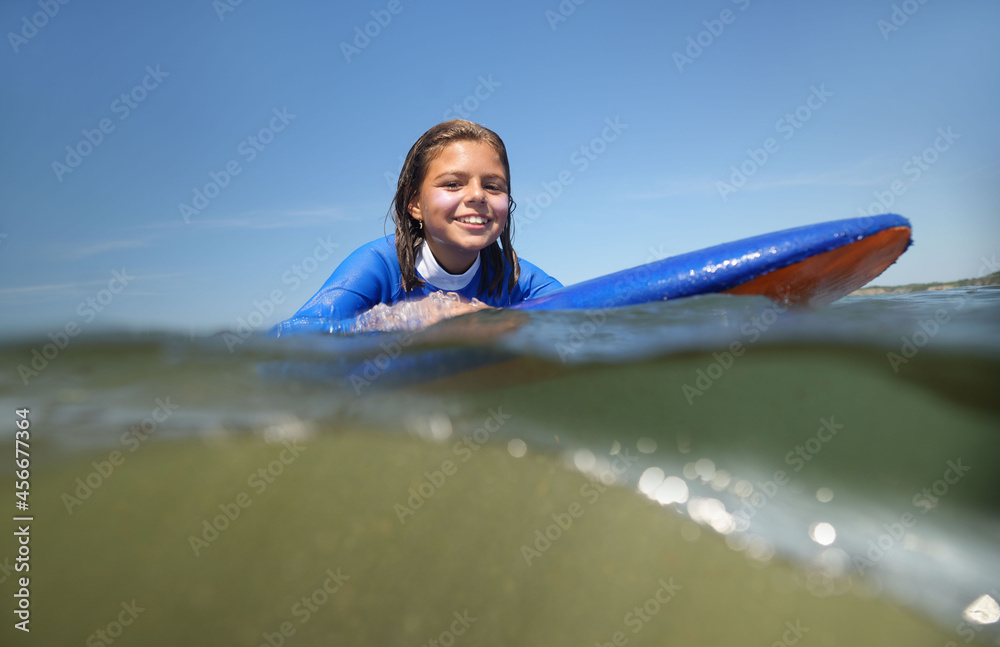 young girl surfing in summer at the beach