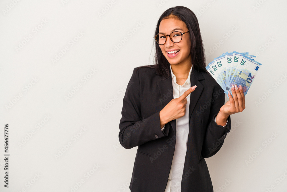 Young business latin woman holding bills coffee isolated on white background smiling and pointing aside, showing something at blank space. Young business latin woman holding bills coffee isolated on white background smiling and pointing aside, showing something at blank space.