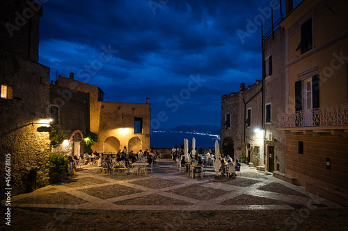 the little square of borgio verezzi full of people in its restaurants during a warm summer evening in 2021