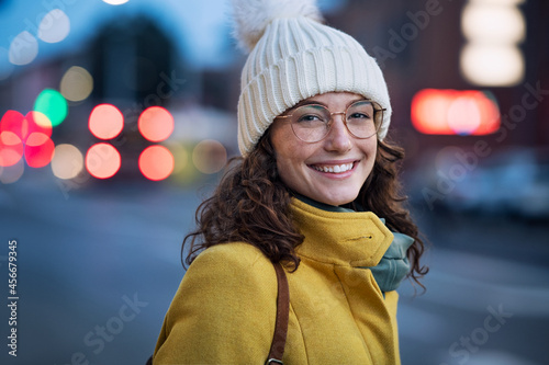 Smiling woman on street during winter dusk photo