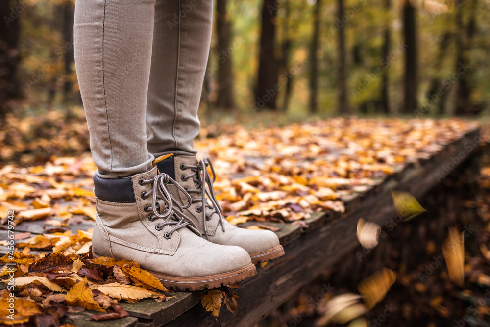 Leather hiking boot on trail in autumn forest