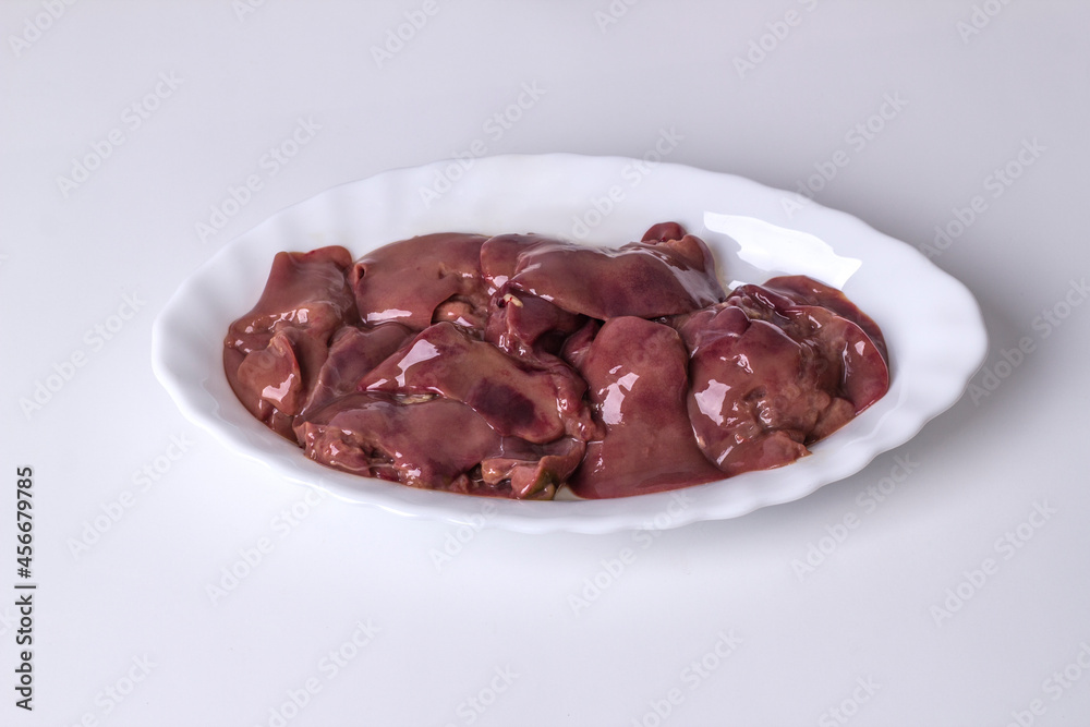 Raw chicken liver meat in a plate on a light background Raw chicken liver meat in a plate on a light background