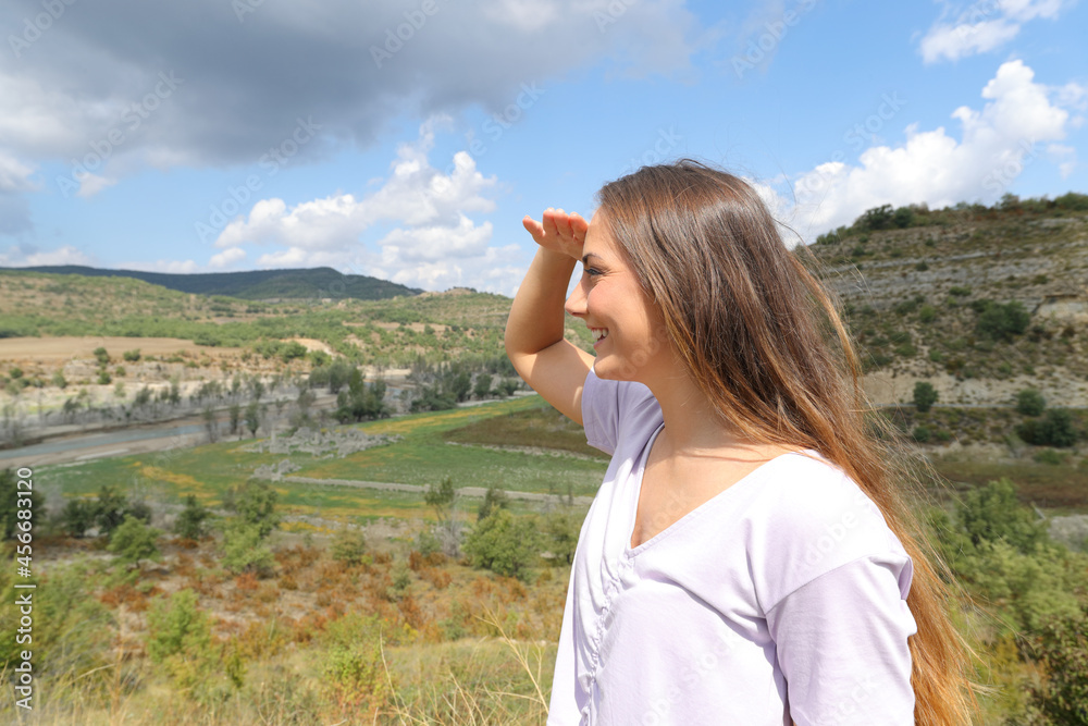 Happy woman protecting from sun with her hand in the mountain Happy woman protecting from sun with her hand in the mountain