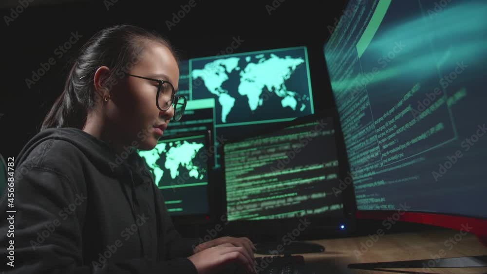 Asian Young Girl Hacker Hacking With Multiple Computer Screens In Dark Room
